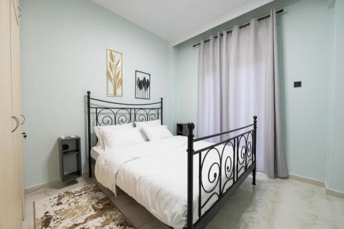 a bedroom with a black bed with white pillows at Serra Modern Apt " Free Parking " Quiet " Near Center in Serres