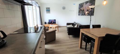 a living room with a kitchen and a dining room at Stuivezandeweg 6 in Callantsoog