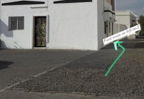 a building with a green arrow next to a building at Ryhana apartment in Al Ain