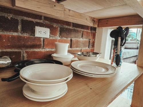 a counter with white plates and utensils on it at Rare Find, Amazing View! Walk to All! in San Pedro La Laguna