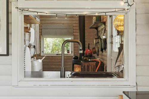 una cocina con fregadero y ventana en Træhus Med Vild Have Ved Sejerøbugten, en Kalundborg