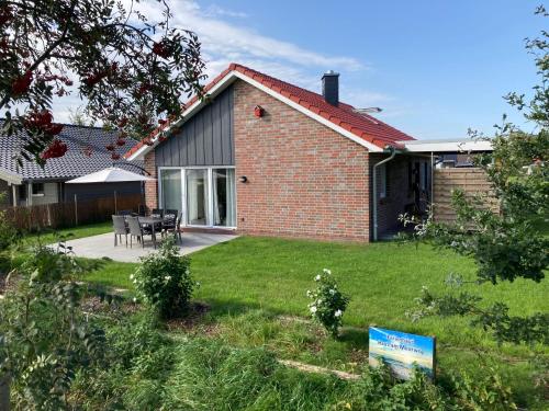 a house with a yard with a patio at Ferienhaus In Sehestedt Mit Garten in Sehestedt