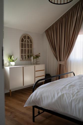 a bedroom with a bed and a dresser and a window at Origini de Rucar in Rucăr