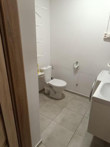 a white bathroom with a toilet and a sink at Myklebostad in Steigen