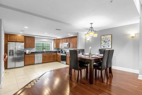a kitchen with a dining room table and chairs at Vibrant 4BR Family Townhome 1 mile from Disney World and Disney Springs in Orlando