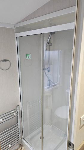 a shower in a bathroom with a glass door at Sunrise Holidays Skegness - Pearl in Skegness