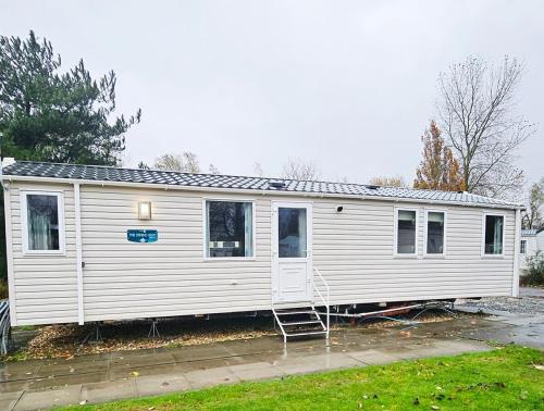 a white house with a ladder in a yard at Sunrise Holidays Skegness - Pearl in Skegness