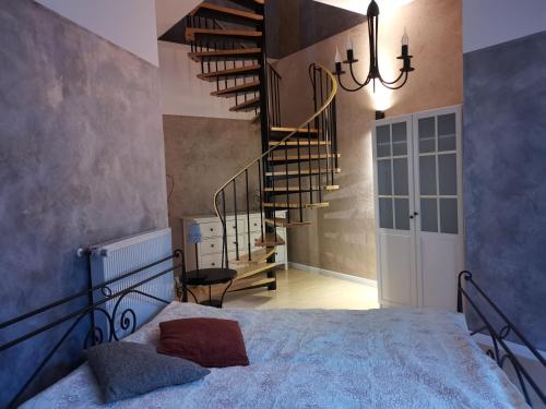 a bedroom with a bed and a spiral staircase at Villa Am Kurpark in Friedrichroda