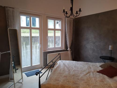 a bedroom with a bed and two windows at Villa Am Kurpark in Friedrichroda
