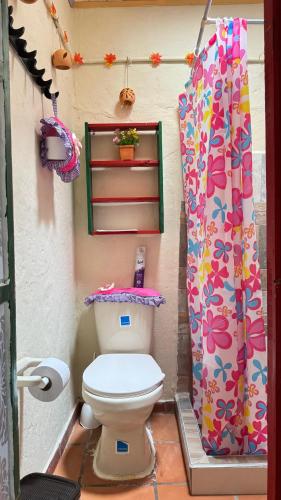 a bathroom with a toilet and a shower curtain at Refugio tornasol in Duitama
