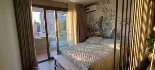 a bedroom with a bed and a large window at Studio Bliss in Neuquén