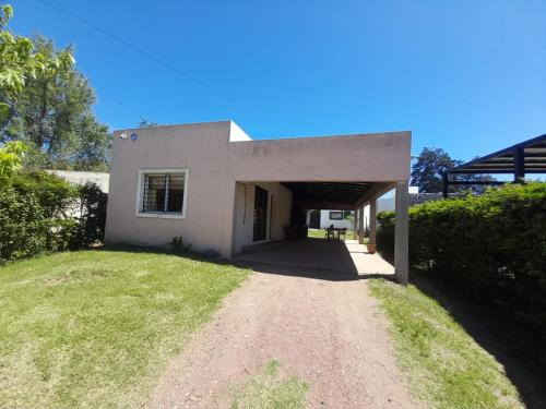 a small white house with a tunnel in a yard at Casa el sueño de Alicia in Villa del Dique