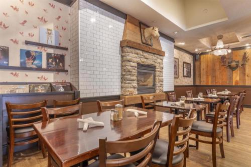 a restaurant with tables and chairs and a fireplace at BEST WESTERN PLUS Carlton Plaza Hotel in Victoria