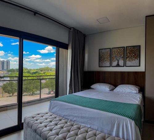 una camera da letto con un letto e una grande finestra di Moov Smart Home – Studios e Apartamentos por Temporada em Cuiabá a Cuiabá