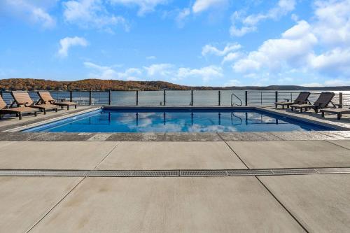 una piscina con sillas y el agua en Lakefront Ozarks Home w Private Dock & Pool, en Damsel