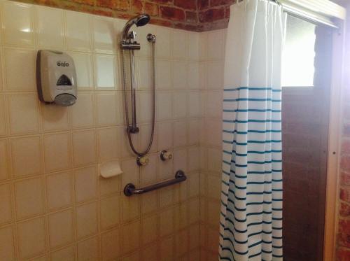 uma casa de banho com chuveiro e cortina de chuveiro em Gloucester Country Lodge Motel em Gloucester