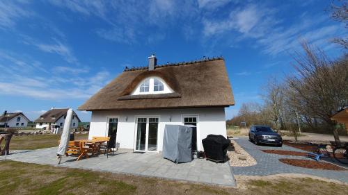 ein kleines weißes Haus mit braunem Dach in der Unterkunft Ferienhaus in Mellnitz mit Großem Garten in Poseritz
