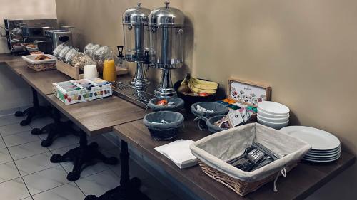 een keukenblad met een tafel, borden en een spoelbak bij Logis Hôtel Blue Garden in Grandvillers