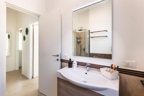 a white bathroom with a sink and a mirror at Villa Paolo in Noto Marina