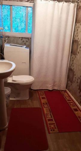 Un baño con una cortina de ducha blanca y un inodoro. en Casa amoblada, en Compu