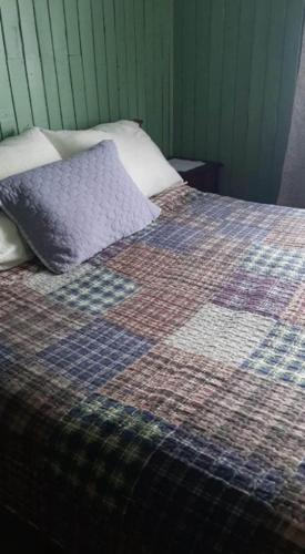 Una cama con una manta y una almohada. en Casa amoblada, en Compu