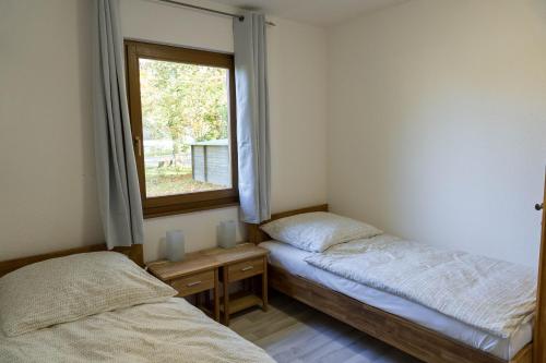 zwei Betten in einem Zimmer mit Fenster in der Unterkunft Haus Aurora Lodge in Frielendorf