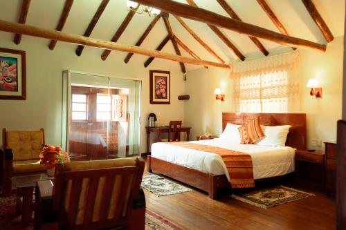 een slaapkamer met een bed en een stoel in een kamer bij Siete Ventanas in Cuzco