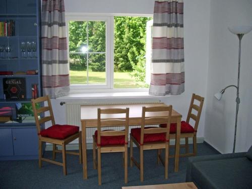 ein Esszimmer mit Tisch und Stühlen und einem Fenster in der Unterkunft Kleines Ferienhaus im Grünen bei Lüneburg in Bardowick