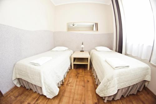 two beds in a small room with a table at Hotel Nevada in Łagów