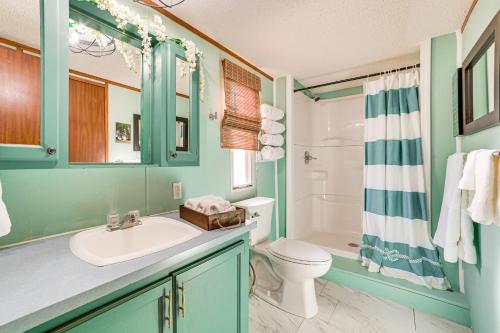 une salle de bain avec un lavabo, des toilettes et une douche dans l'établissement Walk to Houghton Lake! Family Retreat with Patio, à Houghton Lake