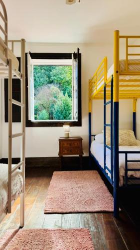 a bedroom with two bunk beds and a window at Oi Braga Hostel in Braga