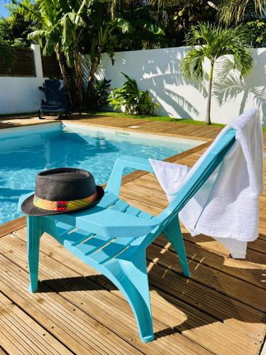 a hat sitting on a chair next to a swimming pool at Ile en Ile in Saint-François