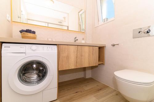 a bathroom with a washing machine and a sink at Hygge Boutique Apartment in Trogir