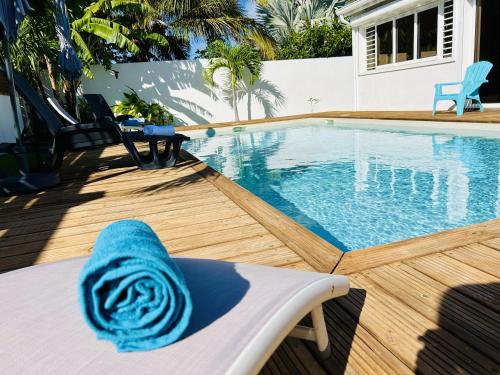 a swimming pool with a blue towel sitting on a chair at Ile en Ile in Saint-François