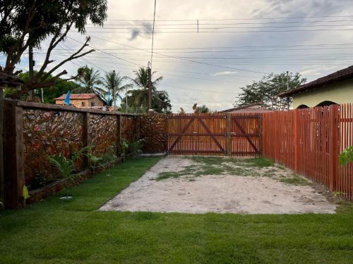 a fence with a red gate in a yard at Refúgio Marajoara in Soure