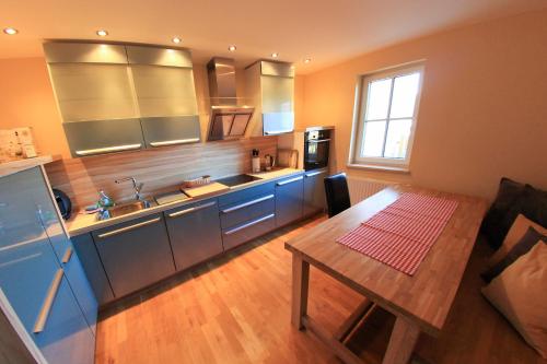 a kitchen with blue cabinets and a wooden table at Ferienwohnung Villa Albatros In Oberdellach in Ober-Dellach