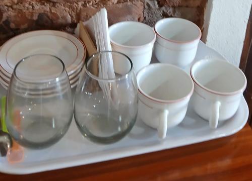 a group of glasses and plates on a shelf at La Blanquita de Areco in San Antonio de Areco