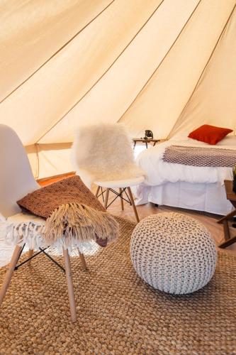 a room with two beds and two chairs in a tent at Starlight Olympic Glamping in Port Angeles