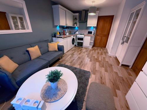 un salon avec un canapé et une table dans l'établissement Homely Stay Langley, à Langley Marish