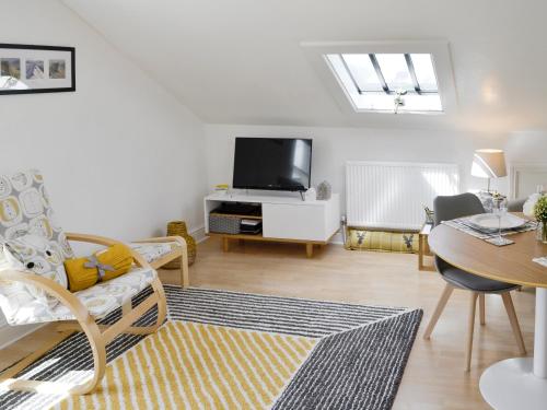 ein Wohnzimmer mit Fernseher und Esstisch in der Unterkunft Loft 10 in Keswick