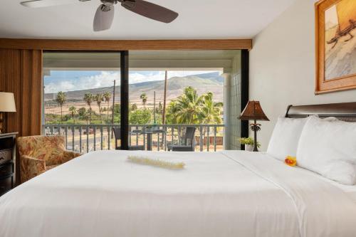Un dormitorio con una gran cama blanca y un balcón. en Lahaina Shores 234, en Wainee