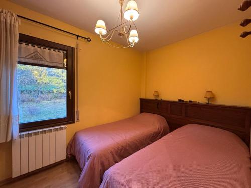 a bedroom with two beds and a window at Apartamentos Ball Benas Edificio Prados de Velarta in Cerler