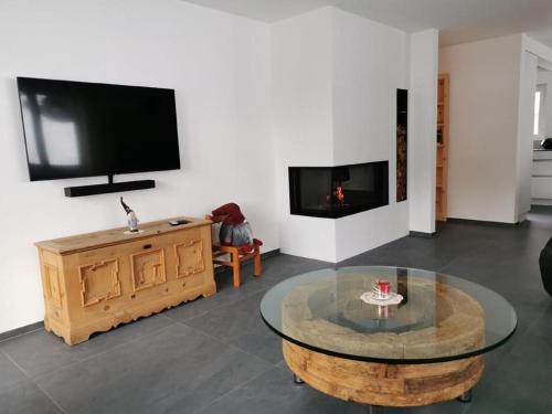 un salon avec une table basse et une télévision à écran plat dans l'établissement Chesa Andrea, Eg, à Pontresina