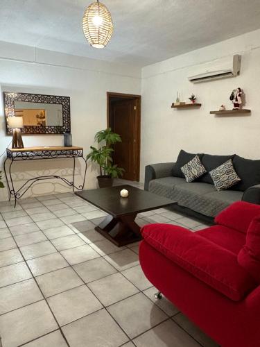 a living room with a red couch and a table at Casa Jardín in Tequila