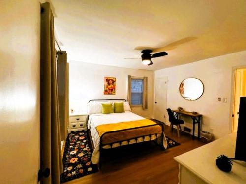 Schlafzimmer mit einem Bett und einem Schreibtisch mit einem Deckenventilator in der Unterkunft La Casa Bella - 5 bedrooms in Louisville