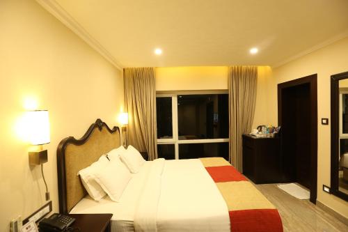 a hotel room with a bed and a window at Hotel Atithi in Guwahati
