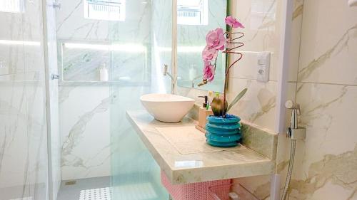 uma casa de banho com um lavatório e um WC num chuveiro em Cobertura com vista panorâmica, piscina, garagem e churrasqueira em Barra de Guaratiba