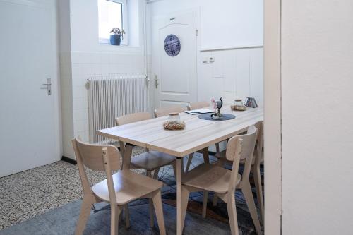 eine weiße Küche mit einem Holztisch und Stühlen in der Unterkunft revLIVING Apartment Octavus Hohenwarth 3 Schlafzimmer in Hohenwarth