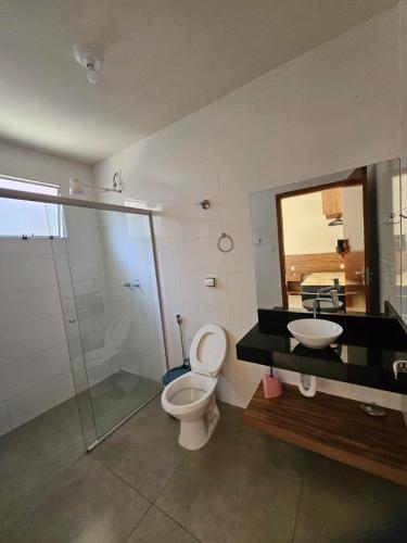 a bathroom with a toilet and a sink and a mirror at Casa do Weber, Jardim Acacias in São João Batista do Glória