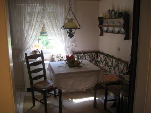 a table and chairs in a kitchen with a window at Große Ferienwohnung Mit Balkon Und Garten in Steinen